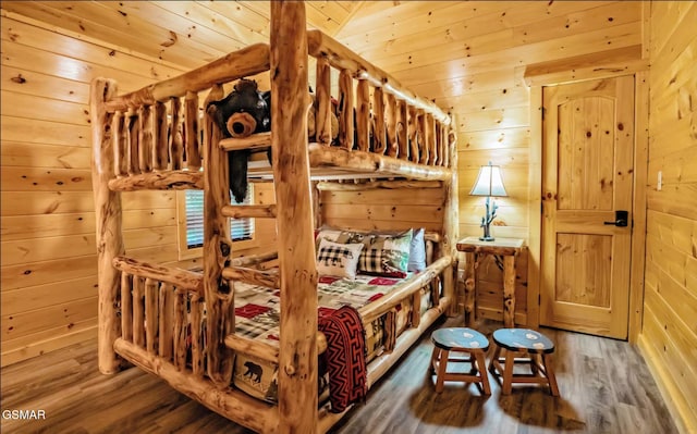 bedroom with hardwood / wood-style flooring, lofted ceiling, wooden walls, and wooden ceiling