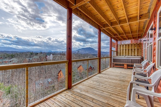 wooden deck with a mountain view and a hot tub