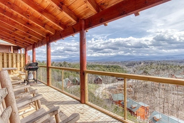 unfurnished sunroom featuring a mountain view and lofted ceiling with beams