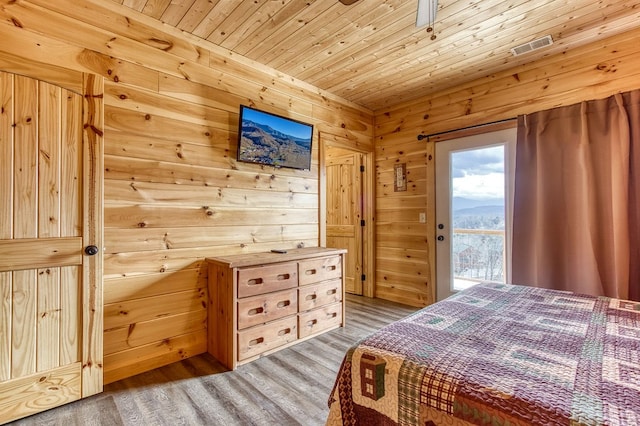 bedroom featuring wood-type flooring, access to outside, wood walls, and wood ceiling