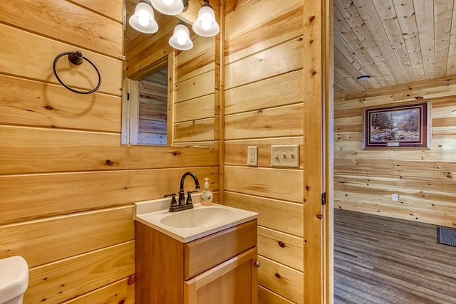 bathroom featuring vanity, wooden walls, and wooden ceiling