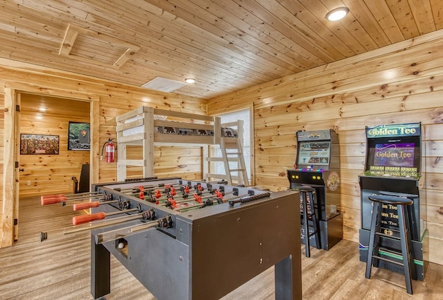 recreation room featuring wooden walls, light hardwood / wood-style flooring, and wooden ceiling