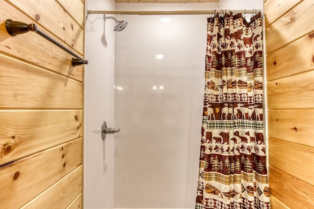 bathroom featuring a shower with curtain and wood walls