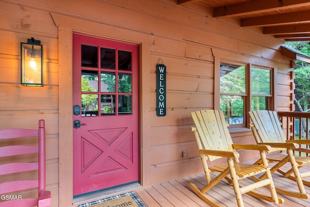 view of exterior entry featuring covered porch