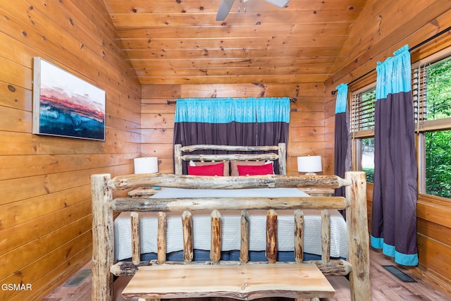 bedroom featuring lofted ceiling, hardwood / wood-style floors, wood ceiling, and wood walls