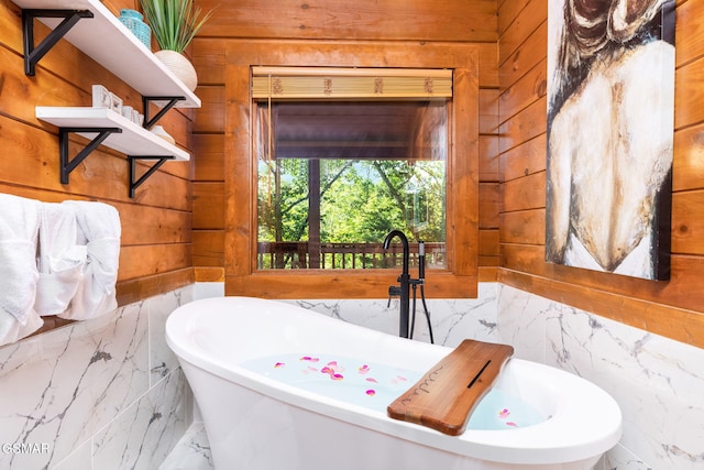 bathroom with a tub and wood walls