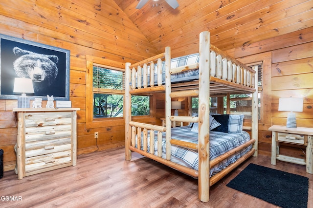 bedroom with hardwood / wood-style floors, high vaulted ceiling, wood walls, ceiling fan, and wood ceiling