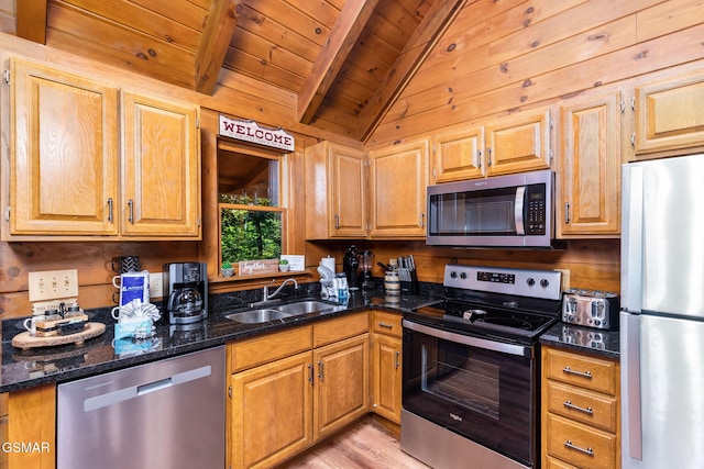 kitchen featuring appliances with stainless steel finishes, sink, dark stone countertops, vaulted ceiling with beams, and wood ceiling