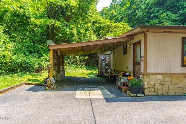 1069 Bryan Rd, Sevierville, TN 37862 - view of parking / parking lot featuring driveway, an attached carport, and a wooded view