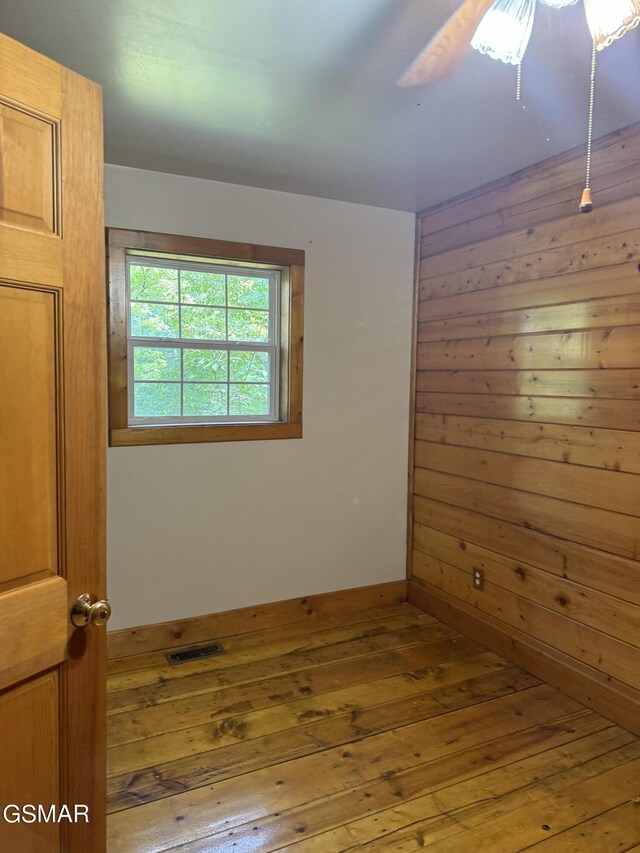 4205 Birds Creek Rd, Sevierville, TN 37876 - empty room featuring visible vents, wood walls, a ceiling fan, and wood-type flooring