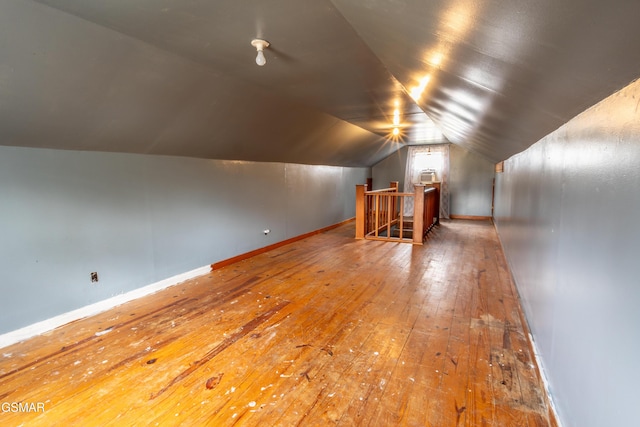 additional living space featuring vaulted ceiling and hardwood / wood-style floors