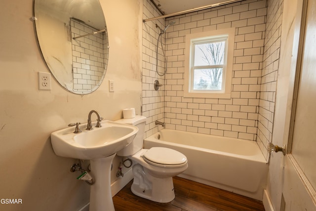 bathroom with toilet, tiled shower / bath combo, and hardwood / wood-style floors