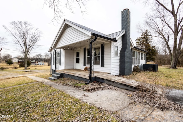 view of front of property featuring a porch, central AC, and a front lawn