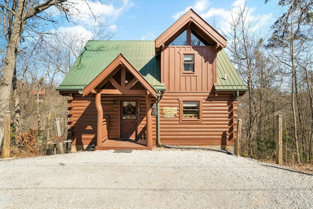 cabin with metal roof and log exterior