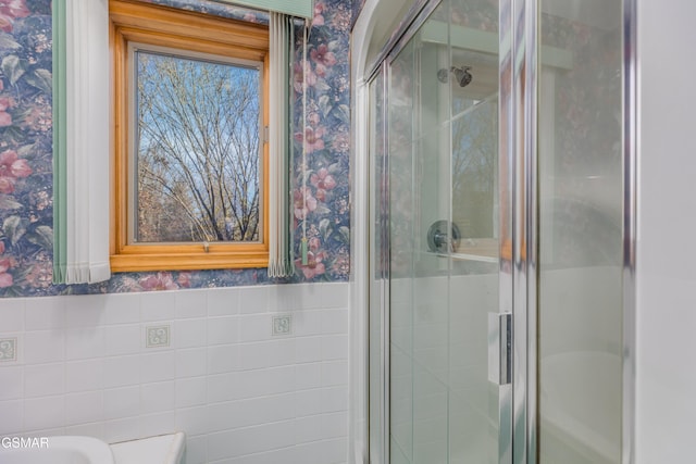 bathroom featuring walk in shower and tile walls