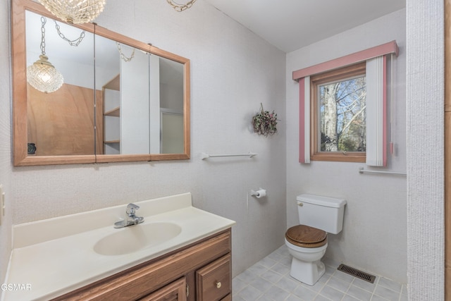 bathroom featuring vanity, tile patterned floors, and toilet