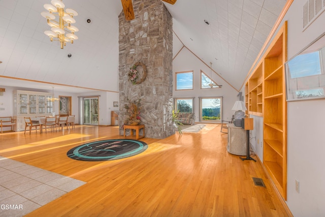 unfurnished living room with hardwood / wood-style flooring, high vaulted ceiling, and a notable chandelier