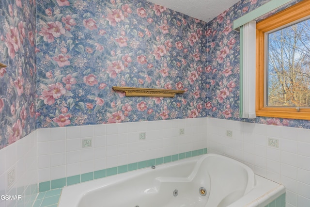 bathroom featuring tiled bath and a textured ceiling