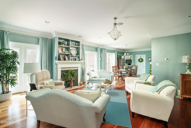 living room with a chandelier, hardwood / wood-style flooring, and crown molding