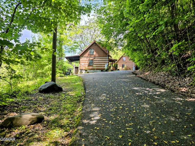 log home with board and batten siding and driveway