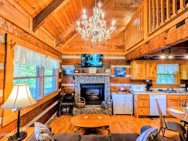 living area with vaulted ceiling with beams, light wood-style flooring, and plenty of natural light