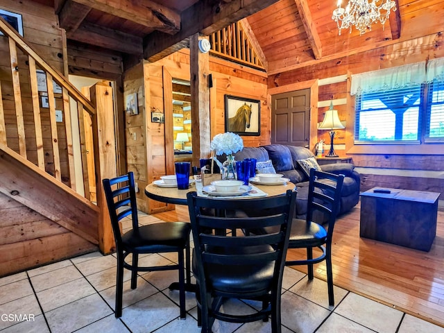 dining room with wood ceiling, tile patterned flooring, and wood walls