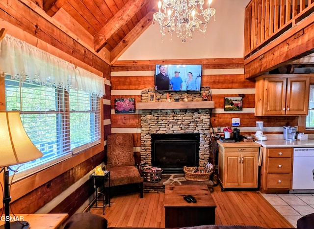 living area with a notable chandelier, a fireplace, wood walls, light wood-style flooring, and vaulted ceiling with beams