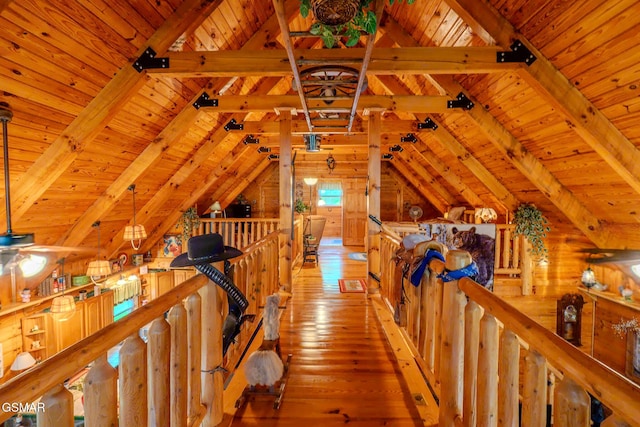 hall featuring an upstairs landing, wooden ceiling, light wood-style flooring, and wooden walls