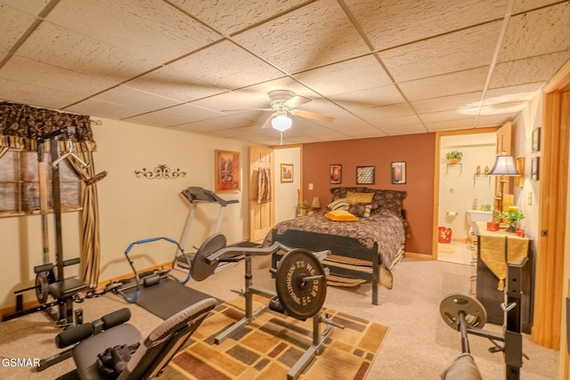 bedroom featuring a paneled ceiling, light carpet, ensuite bath, a ceiling fan, and baseboards