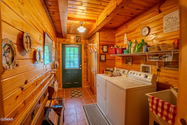 clothes washing area with wooden walls, washer and clothes dryer, wooden ceiling, and tile patterned floors