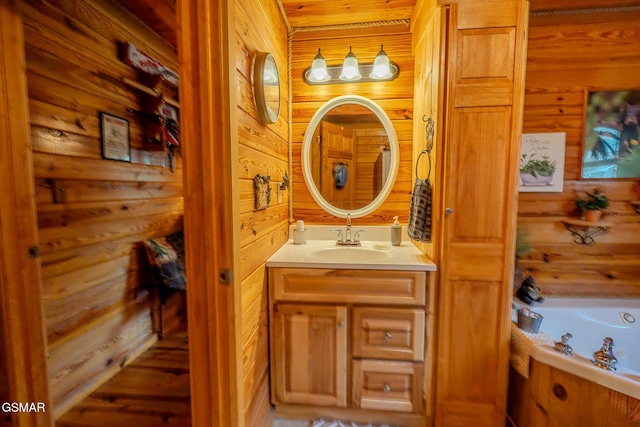 full bathroom featuring wood walls, a whirlpool tub, and vanity