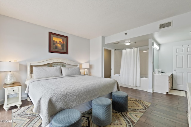 bedroom featuring a textured ceiling, wood finished floors, and visible vents