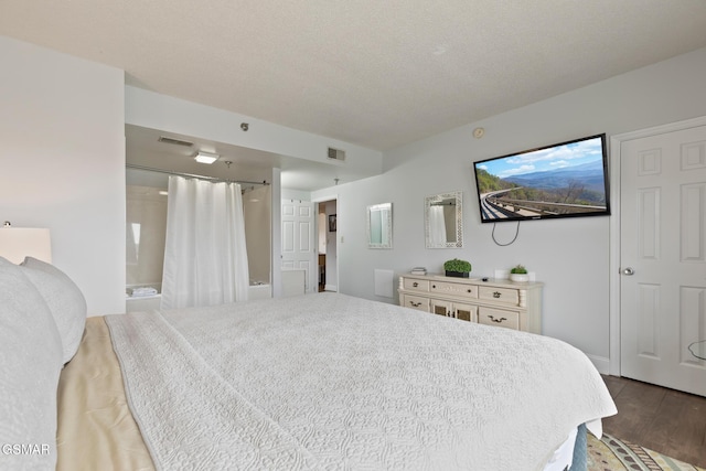 bedroom with visible vents, a textured ceiling, and wood finished floors