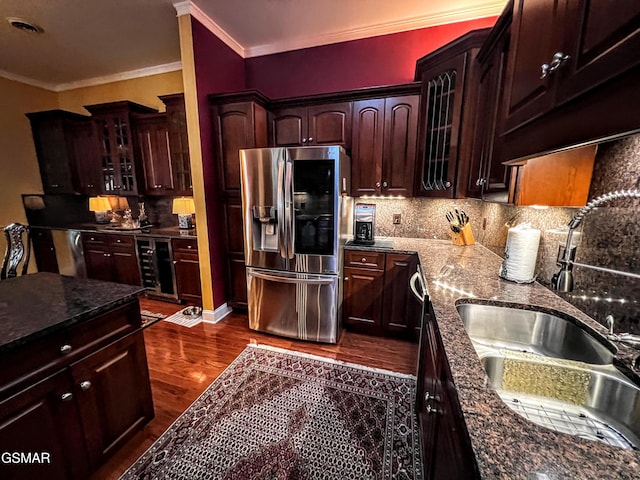 1042 Fine Glen Dr, Sevierville, TN 37862 - kitchen featuring stainless steel fridge, ornamental molding, dark wood-type flooring, tasteful backsplash, and glass insert cabinets