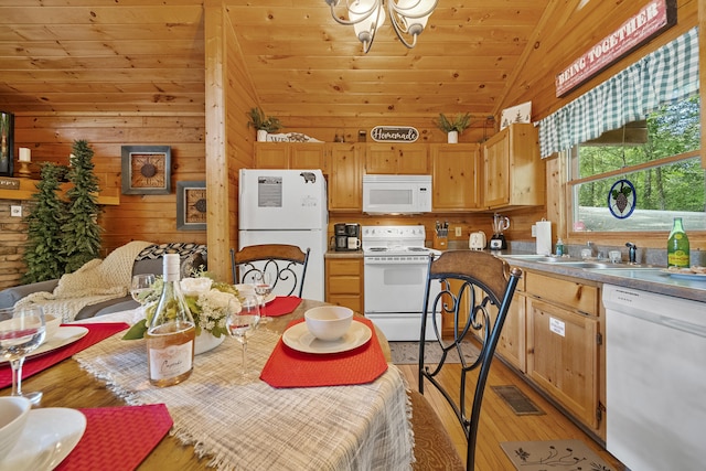 dining space with sink, wood walls, light hardwood / wood-style floors, vaulted ceiling, and wood ceiling