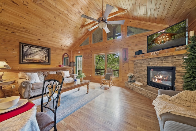 living room featuring beamed ceiling, light hardwood / wood-style flooring, wood ceiling, and wood walls