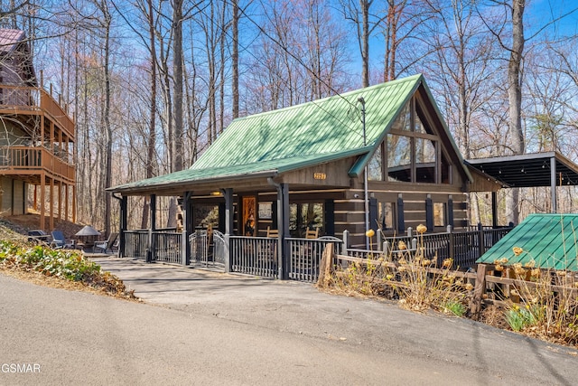 cabin featuring fence and metal roof