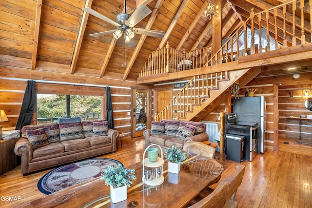 living room with high vaulted ceiling, wood walls, and wood-type flooring