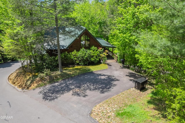 view of property's community featuring driveway and a wooded view