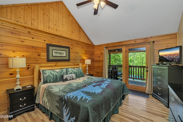 bedroom with wood walls, lofted ceiling, ceiling fan, access to outside, and light wood-type flooring