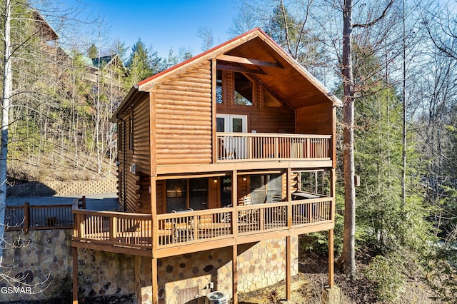 back of house with a deck and faux log siding