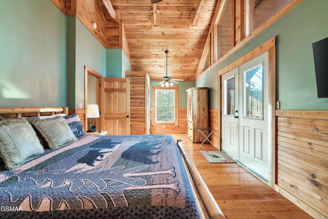 bedroom featuring beam ceiling, wood ceiling, wainscoting, wooden walls, and hardwood / wood-style floors