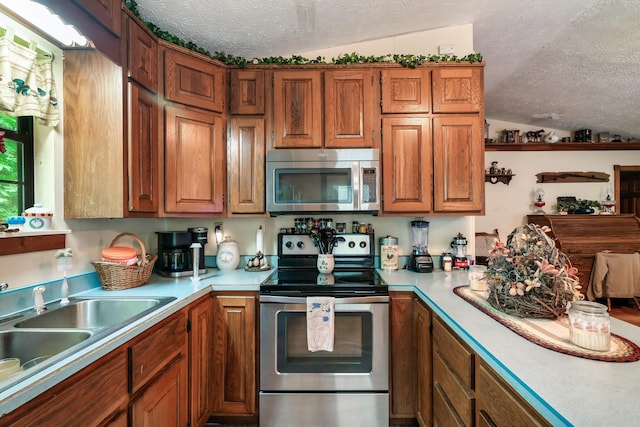 2655 Craig Circle Way, Cosby, TN 37722 - kitchen featuring stainless steel appliances, a textured ceiling, light countertops, and brown cabinets