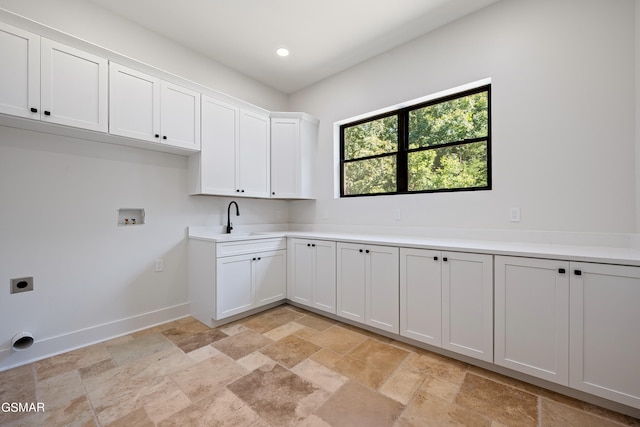 laundry room featuring electric dryer hookup, cabinets, sink, and hookup for a washing machine