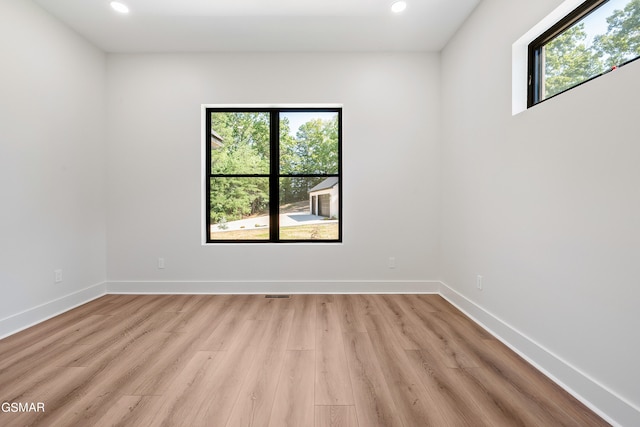 unfurnished room featuring light hardwood / wood-style floors and plenty of natural light