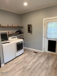 washroom with light wood-type flooring, independent washer and dryer, and electric panel