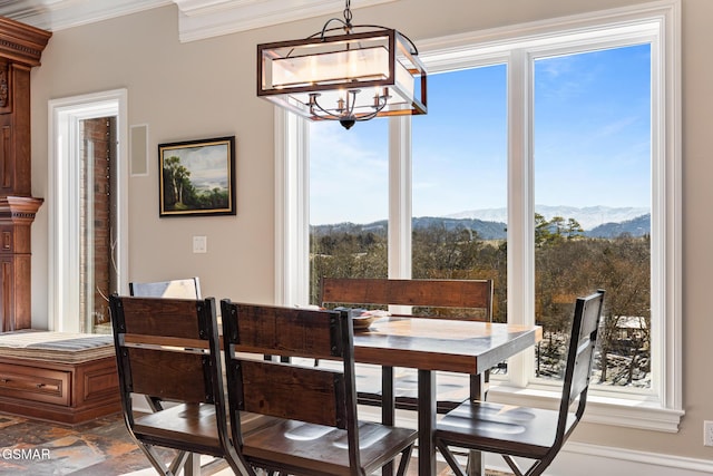 dining space featuring crown molding, a mountain view, a wealth of natural light, and a chandelier