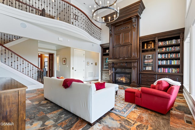 living area with stone tile flooring, visible vents, and crown molding