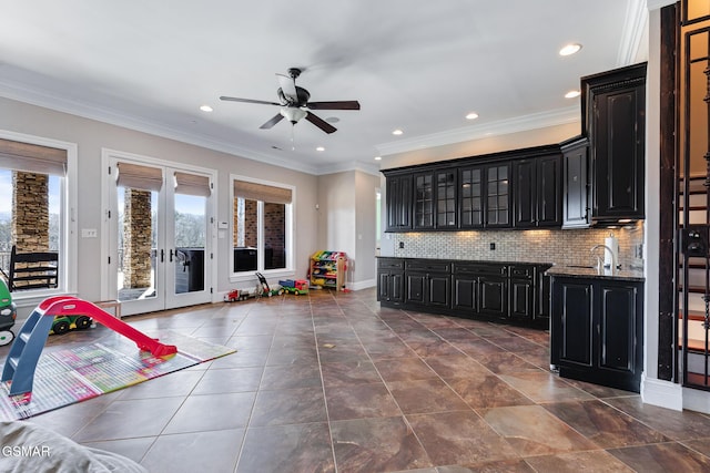 kitchen featuring decorative backsplash, glass insert cabinets, french doors, crown molding, and dark cabinets