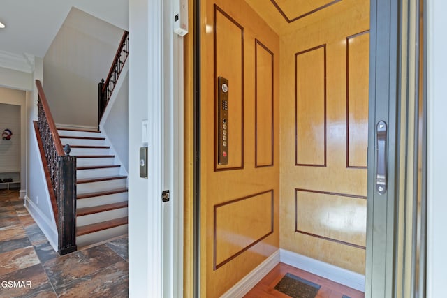 interior details featuring elevator and baseboards